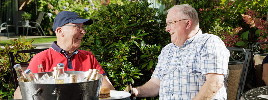 Two older gentlemen sharing a cold one at a bbq