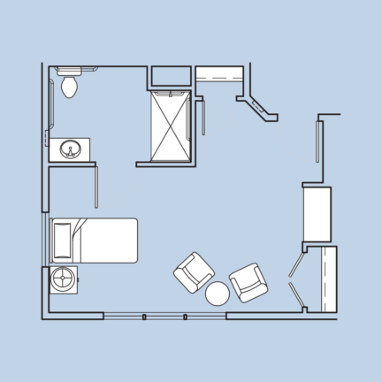 Room layout with bed, two chairs, table, sink, toilet, and shower. Minimal design with a functional floor plan.