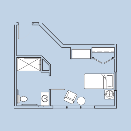 The image is a blueprint of a compact studio apartment with a bed, chair, desk, bathroom, and small kitchen area.