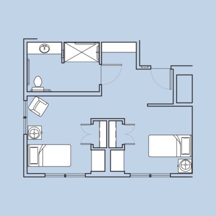 Floor plan of a small bathroom and bedroom layout, featuring two beds, a toilet, shower, basin, and basic furniture arrangements.